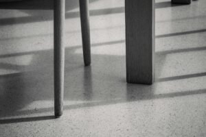 Schwarze Gummi-Möbelstopper unter den Beinen eines Sofas auf glattem Boden