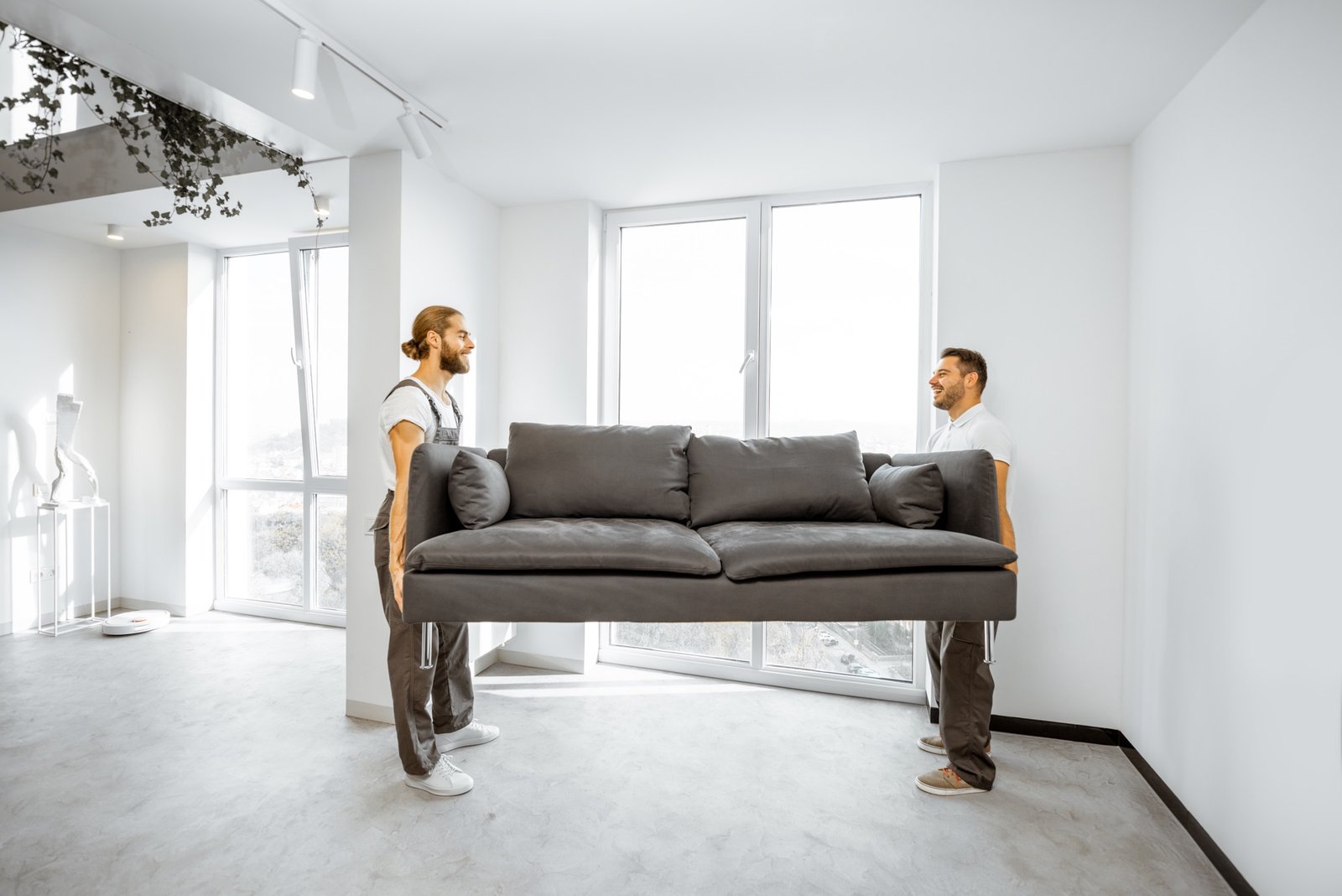 Schweres Sofa wird vorsichtig auf Parkettboden verschoben